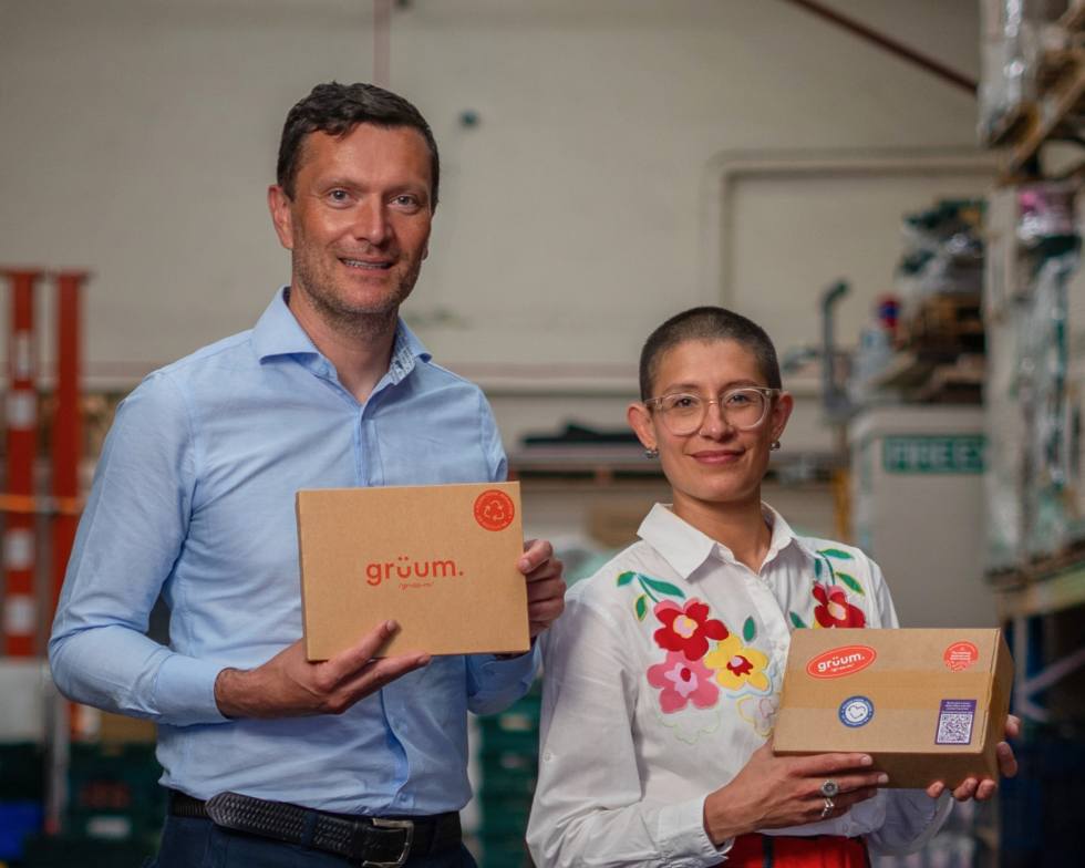The owners of Grüum pose in a warehouse with Grüum products.